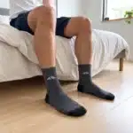Sivé ponožky s červenými detailmi na nohách v spálni