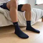 Tmavomodré klasické ponožky na nohách v spálni